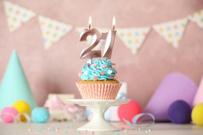 Babeczka na 21 urodziny ze świeczkami numerycznymi na białym stole