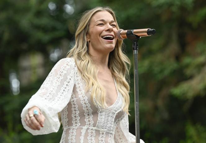 leann rimes śpiewa na scenie z mikrofonem w białej koronkowej sukience