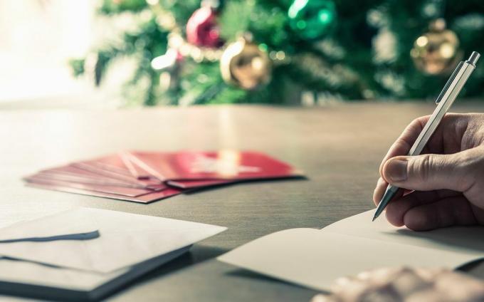 pisanie wiadomości w postaci kartek świątecznych przed choinką