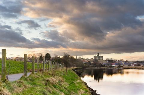 klimatyczne niebo odbijające warkworth zamek w rzece kokietka