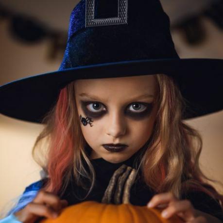 portret małej czarownicy halloween z pająkiem namalowanym na twarzy