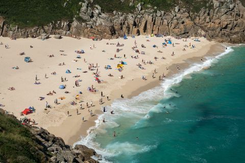 Ludzie cieszą się dobrą pogodą na plaży Porthcurno w pobliżu Penzance 