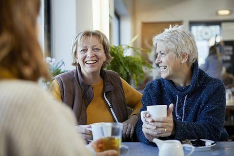 para lesbijek i dorosła córka piją kawę i rozmawiają w kawiarni