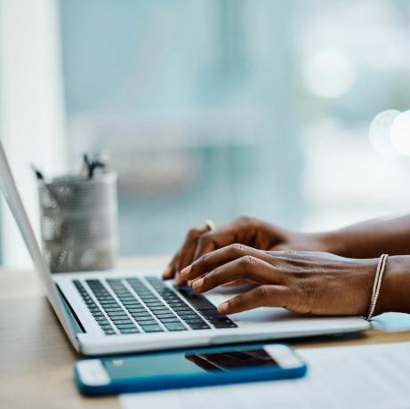 zbliżenie czarnej bizneswoman piszącej na klawiaturze laptopa w samym biurze