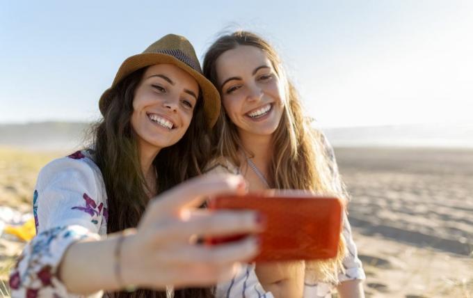 dwóch najlepszych przyjaciół robi selfie ze smartfonem na plaży