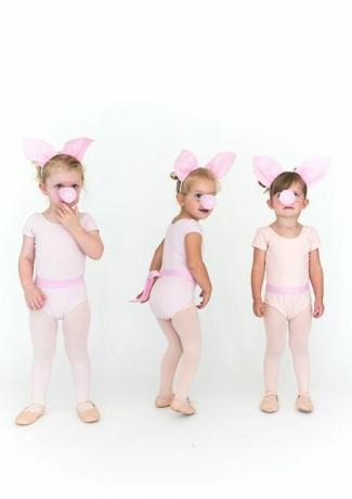 małe dziewczynki w różowych rajstopach i kombinezonach ze świńskimi uszami i świńskimi pyszczkami