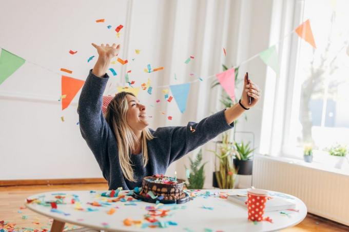 jedna kobieta, piękna młoda kobieta, używająca smartfona do robienia sobie selfie, sama świętuje swoje urodziny w domu