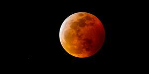 krwawy księżyc lub księżyc w pełni z czerwonawym cieniem w wyniku całkowitego zaćmienia Księżyca na nocnym niebie