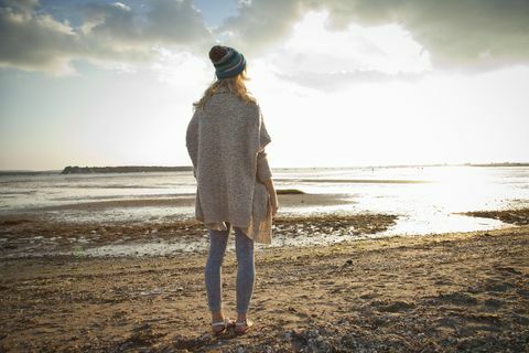 Młoda kobieta ono wpatruje się na Bournemouth plaży, Dorset, UK