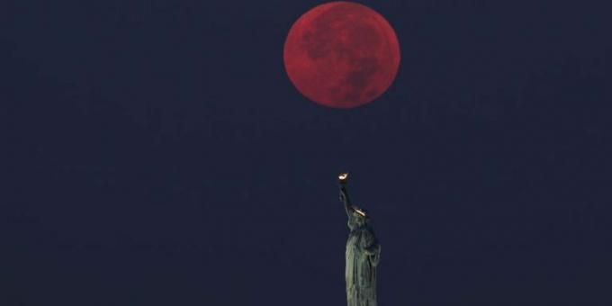 księżyc w pełni zachodzi za Statuą Wolności w Nowym Jorku