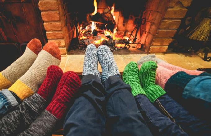 nogi widok szczęśliwej rodziny w ciepłych skarpetkach przed kominkiem zimowa, miłość i przytulna koncepcja skupiają się na środku szarych wełnianych skarpet