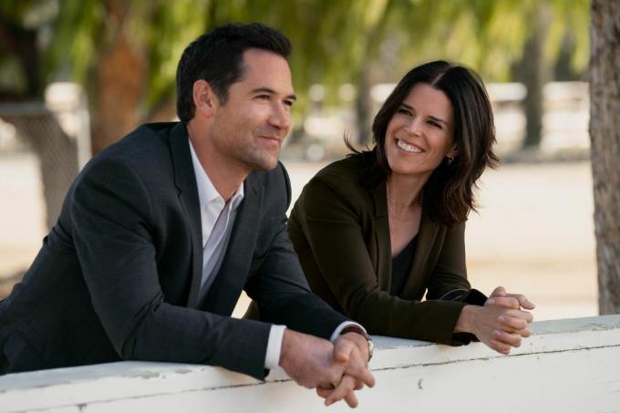 dwie postacie, które w serialu są byłym mężem i żoną, pochylają się nad ścianą na zewnątrz, uśmiechają się, rozmawiają